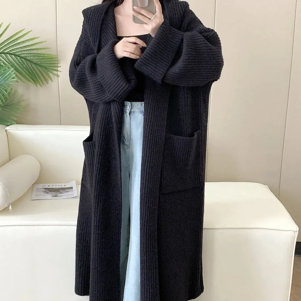 Loose grey hooded cardigan coat for women with raglan sleeves on a hanger