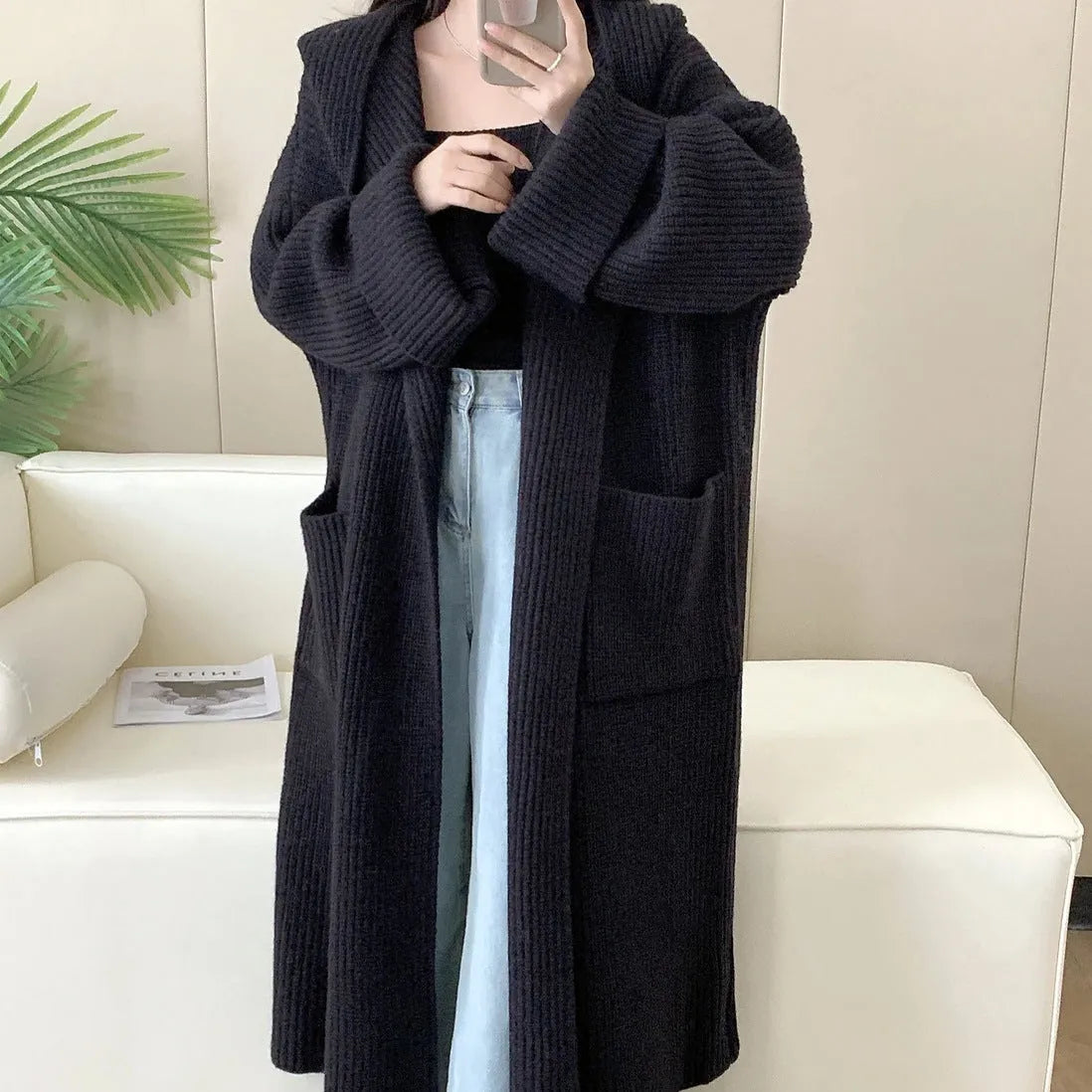 Loose grey hooded cardigan coat for women with raglan sleeves on a hanger
