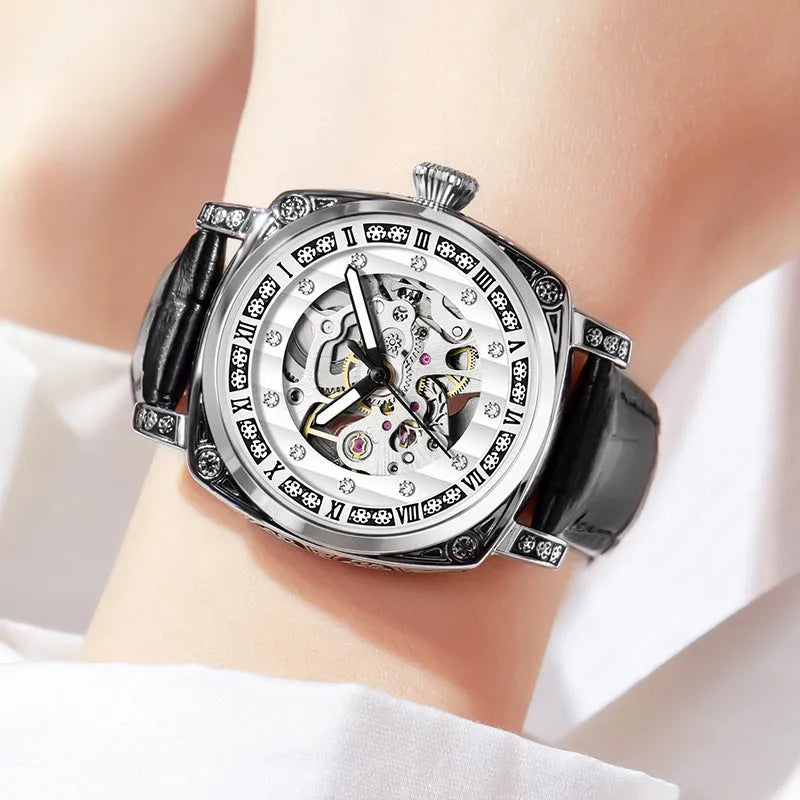 Mechanical watch with luminous hands and a black leather strap on a wrist.