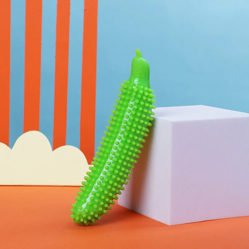 Green cucumber-shaped dog chew toy for teething and bite training on a white background.