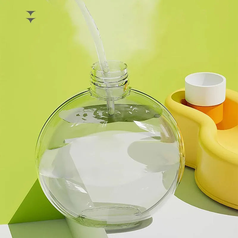 Green portable dog travel water bottle and bowl dispenser on a table.