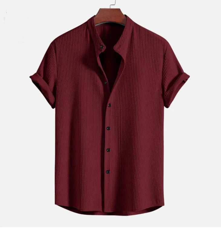 A man's loose-fitting short sleeve casual shirt in a solid colour, made from lightweight polyester fabric.