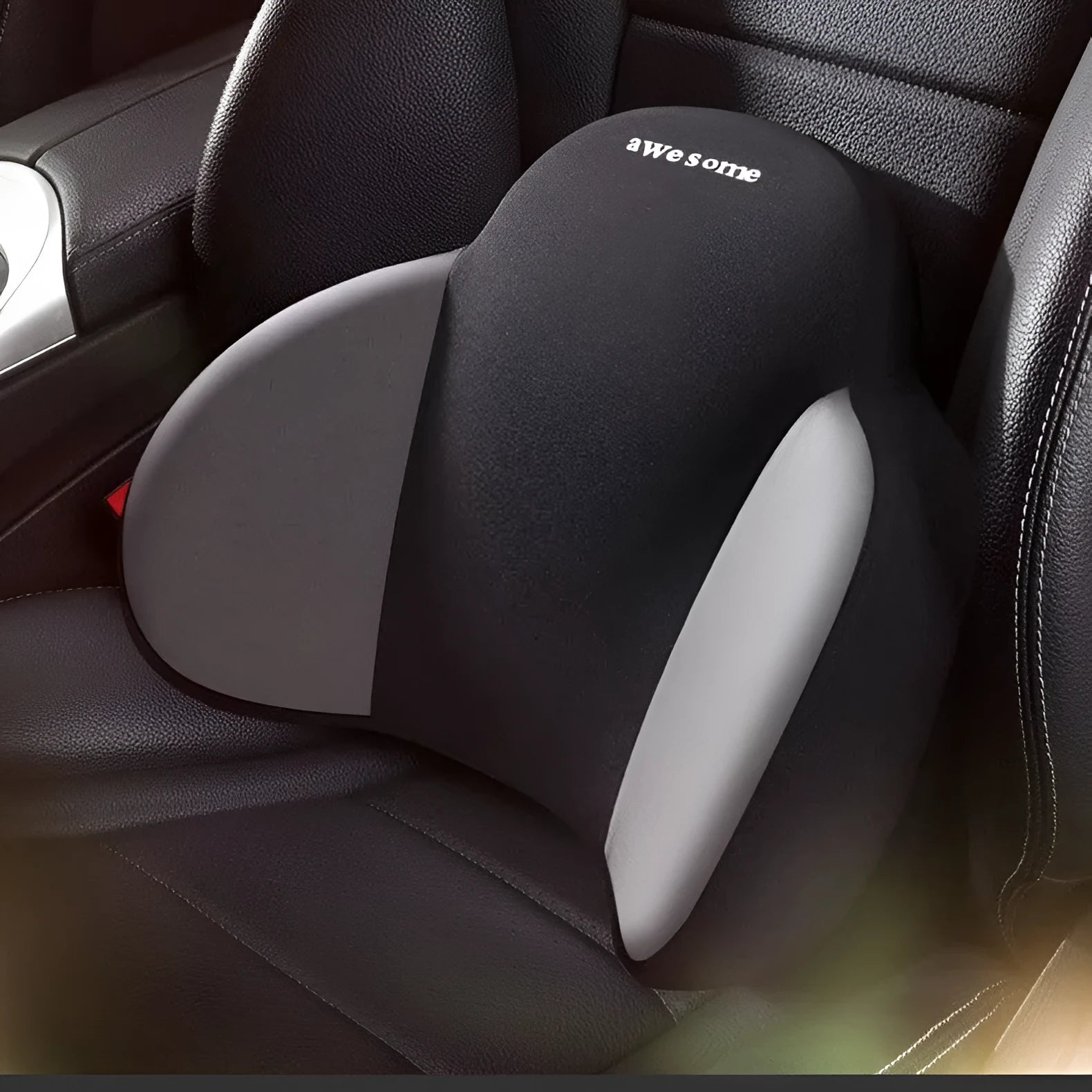 Black memory foam triangle lumbar support pillow and headrest on a car seat.