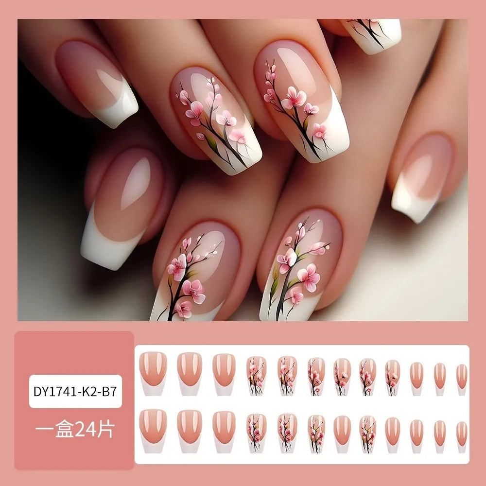 Plum blossom style nail tips with simple white edge French design and starry sky pattern on a table