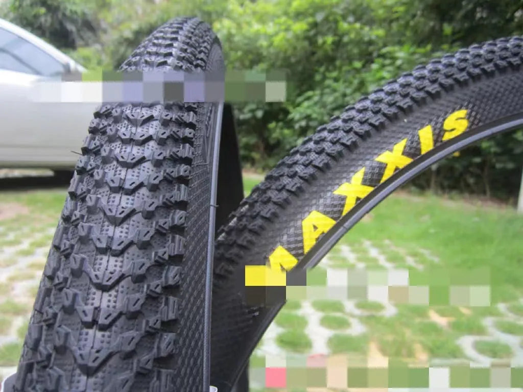 A mountain bike tyre showing tread pattern, with options for 26, 27.5, and 29-inch wheel sizes.