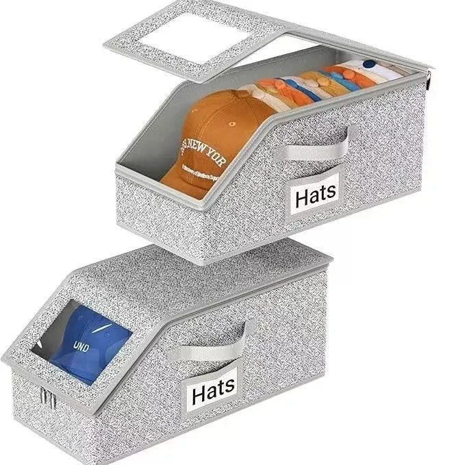 Grey foldable woven fabric storage box with lid, shown next to baseball caps.