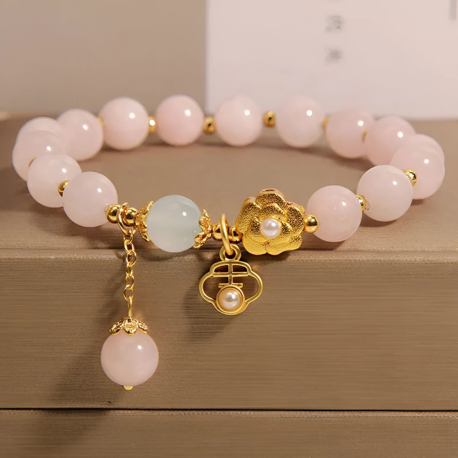 Women's pink crystal bracelet with a refined grace flower design on a wrist.