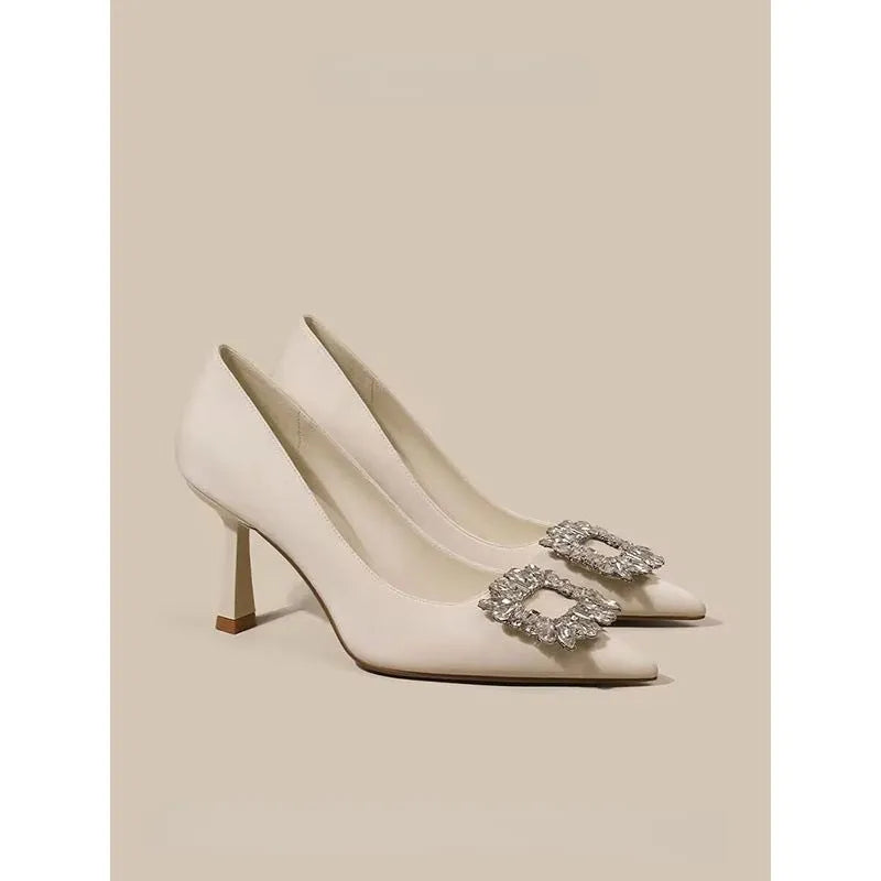 Women's creamy-white pointed toe stiletto high heel pumps for formal wear.