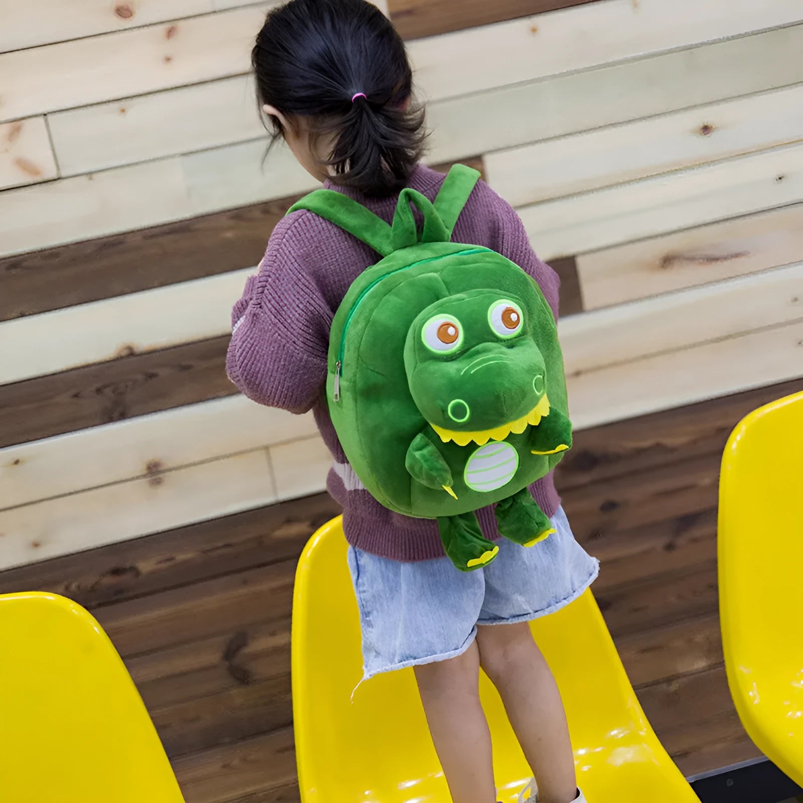 Dinosaur plush backpack for children with embroidered design in blue colour showing soft handle and animal pattern