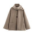 Women's long grey polyester overcoat with artificial fur collar on a model, showcasing street fashion style.