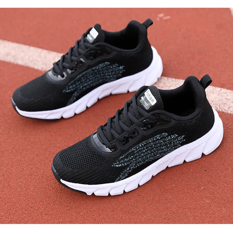 Low-top black and white running sneaker with cross strap and round toe on MD sole.