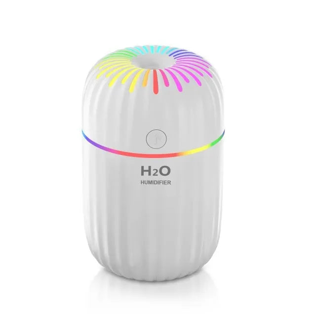 White A5 model mini USB humidifier with 300ml tank on a desk next to a laptop.
