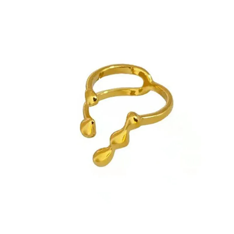 Gold tone brass ring with open circle design and central sphere on a person's finger.