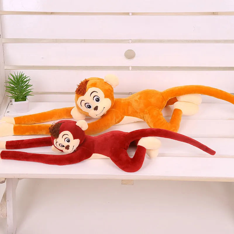 Long arm pink plush monkey toy hanging over a curtain rod as room decoration.