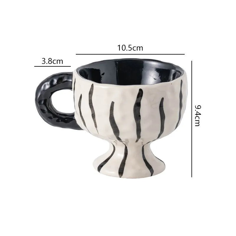 A hand-pinched ceramic mug with an irregular shape in a solid colour, shown on a table.