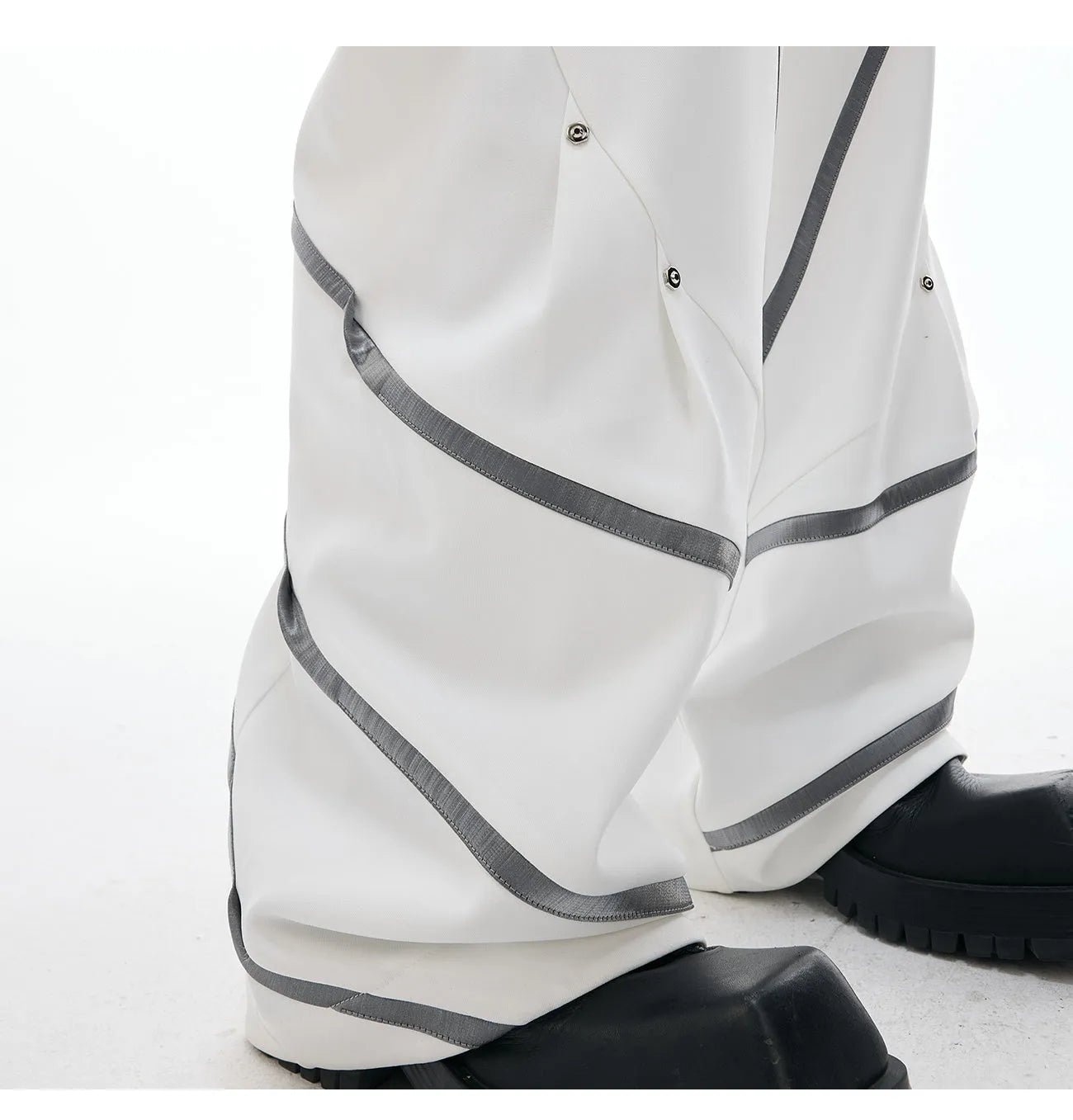 Men's black trousers with metal striped rivet and pleated detail on a three-dimensional cut.