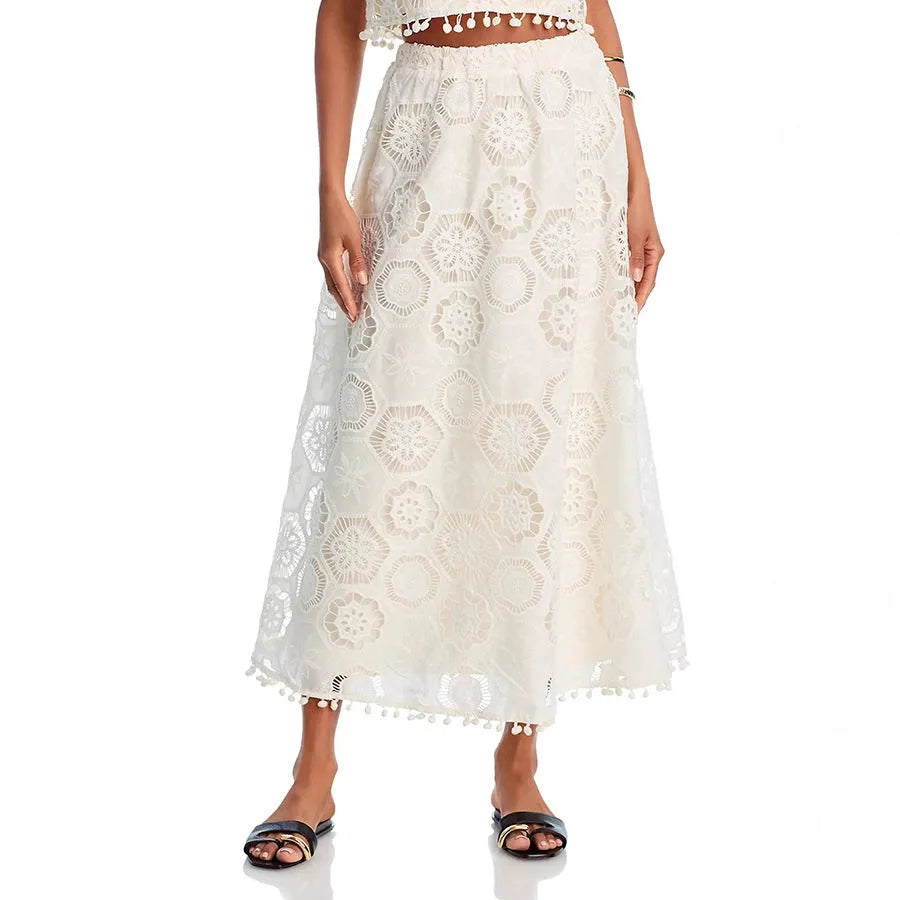 White women's sleeveless top and long skirt set with embroidery detail, laid flat.