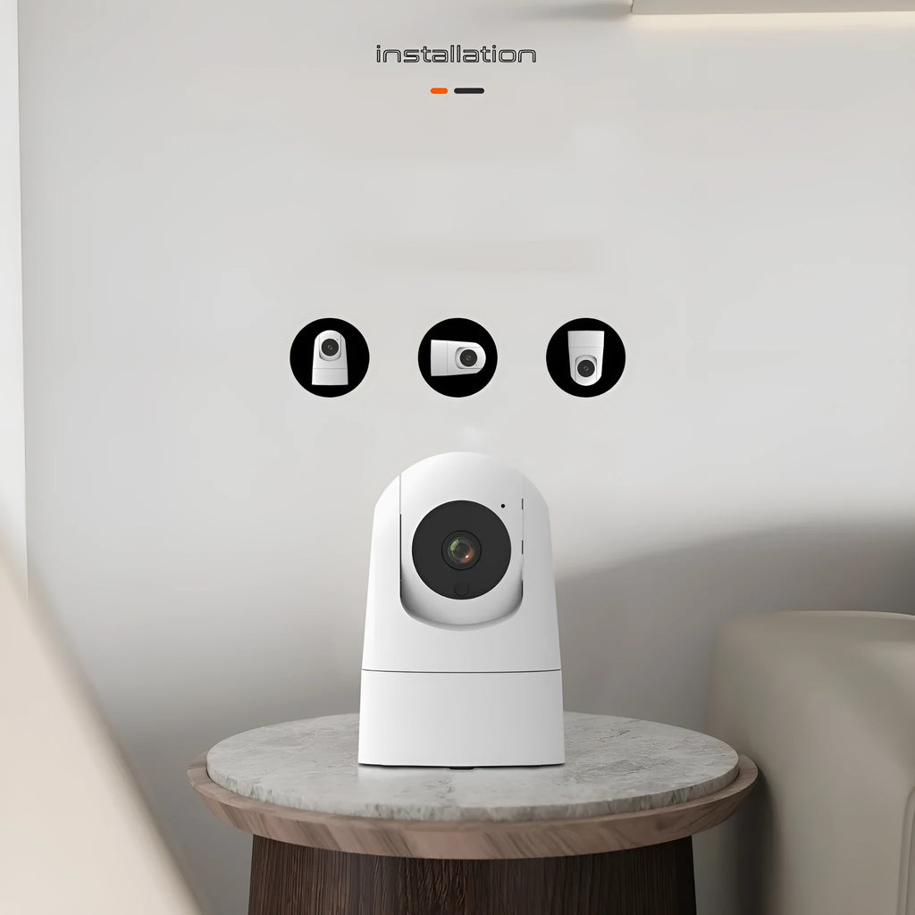 White indoor security camera with wide-angle lens on a shelf, showing companion app on a mobile phone.