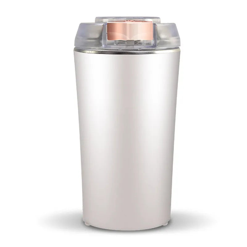 Blue mini flour mill and grinder with stainless steel construction on a kitchen counter.
