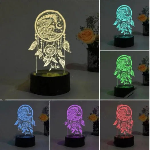 Black-based acrylic dream catcher night light with remote control on a table, showing colourful light mode.