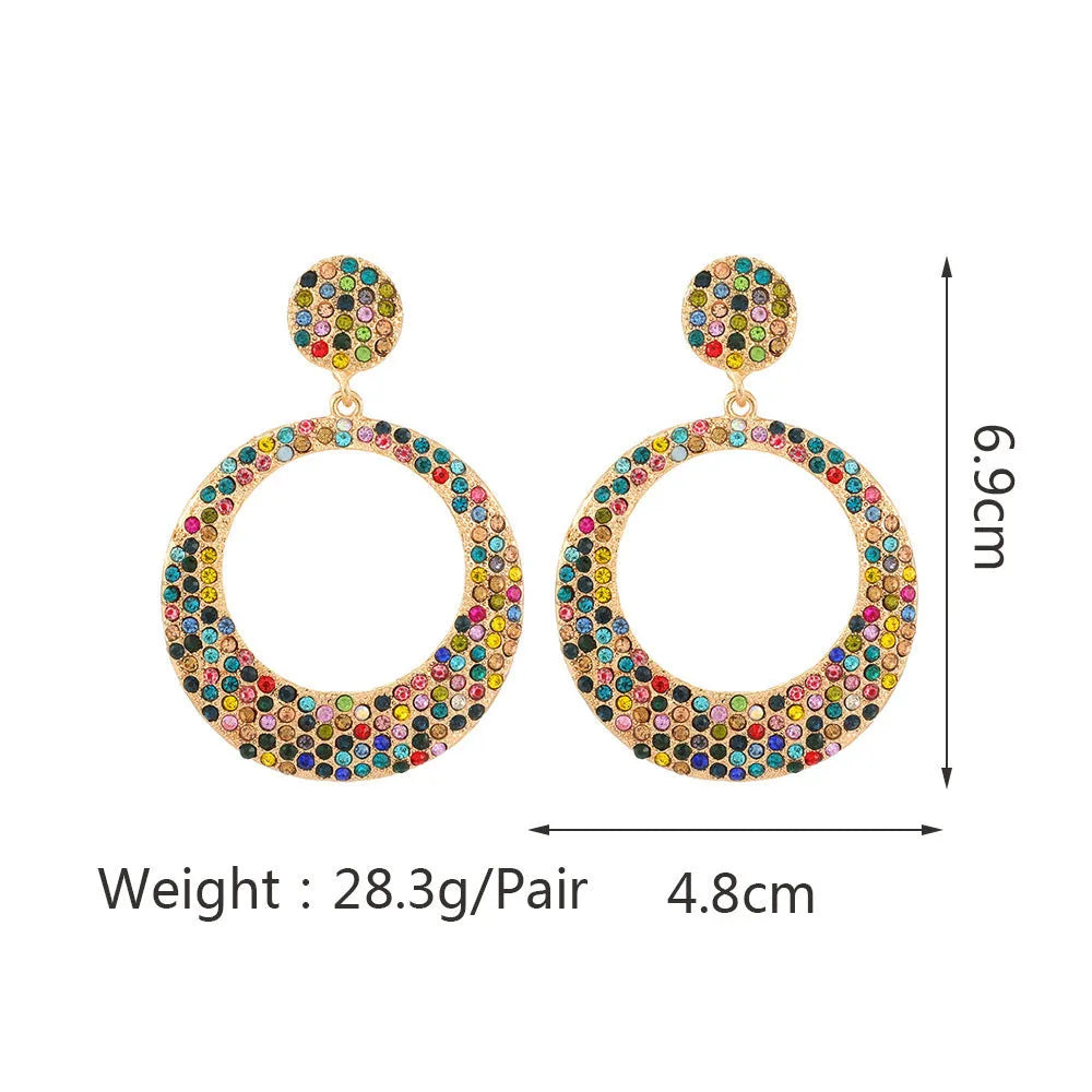 A pair of large round metal alloy pendant earrings with colourful cartoon diamond decorations.