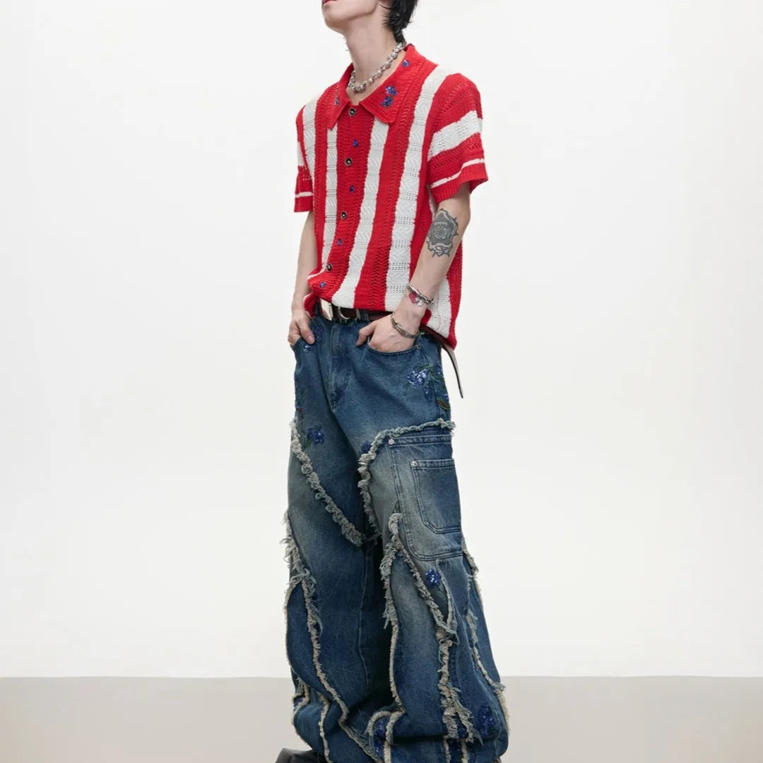Man wearing a red and black patchwork striped knitted short-sleeved shirt with a loose fit.