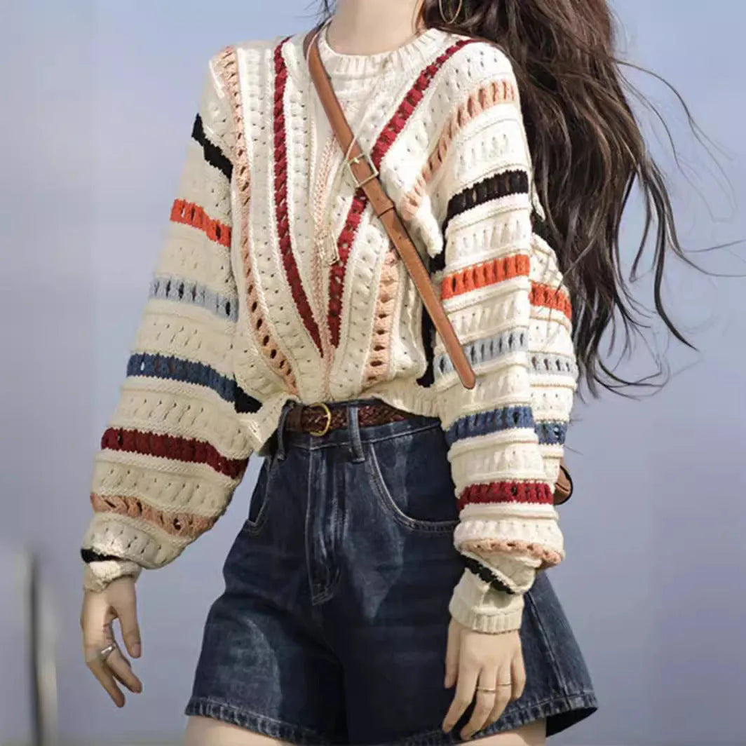 Retro rainbow striped pullover sweater with batwing sleeves on a hanger.