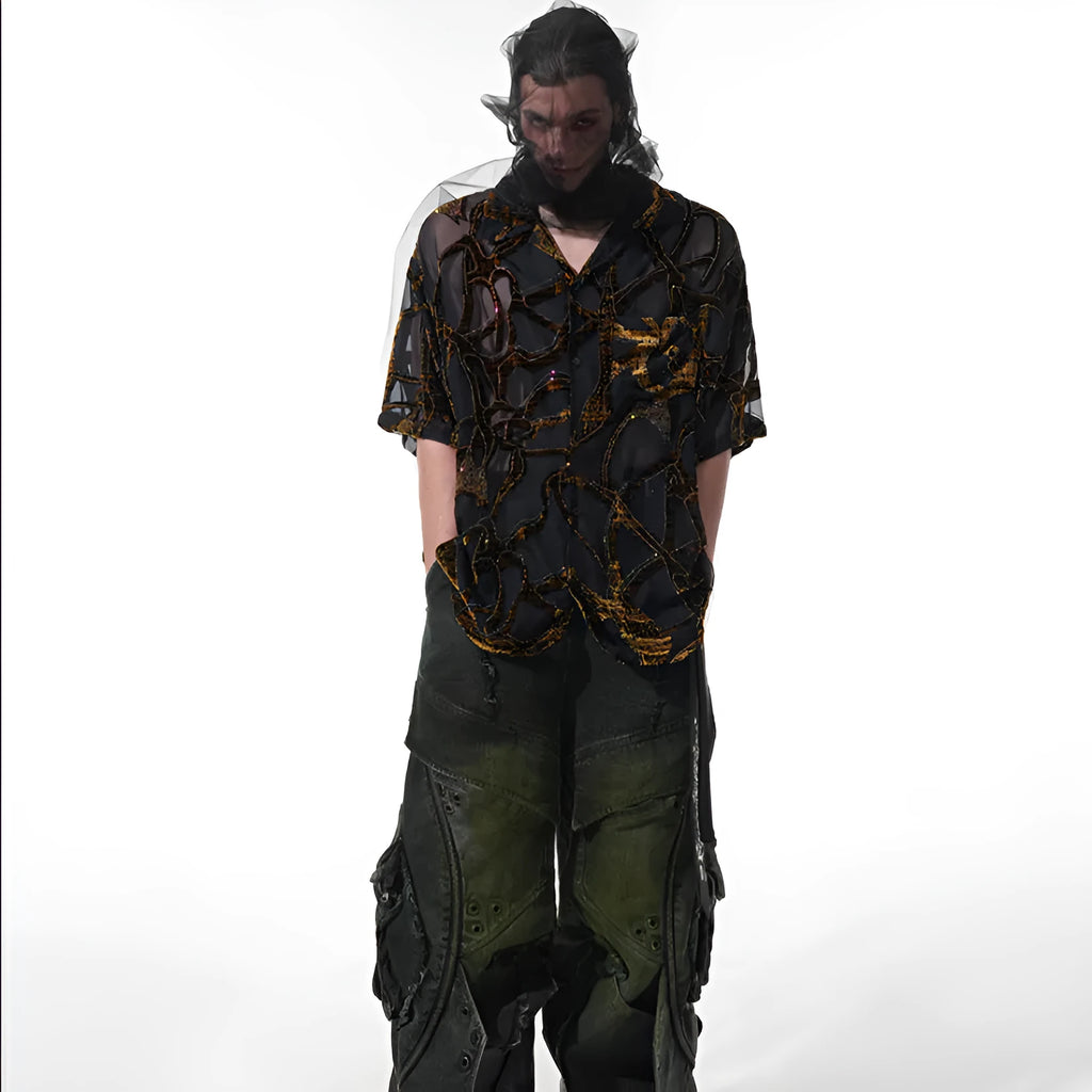 Man wearing a loose-fit black short-sleeved shirt with a translucent snake pattern print and lapel collar.