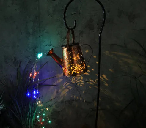 Solar-powered iron garden lamp with a tapered butterfly design and warm white LED light.