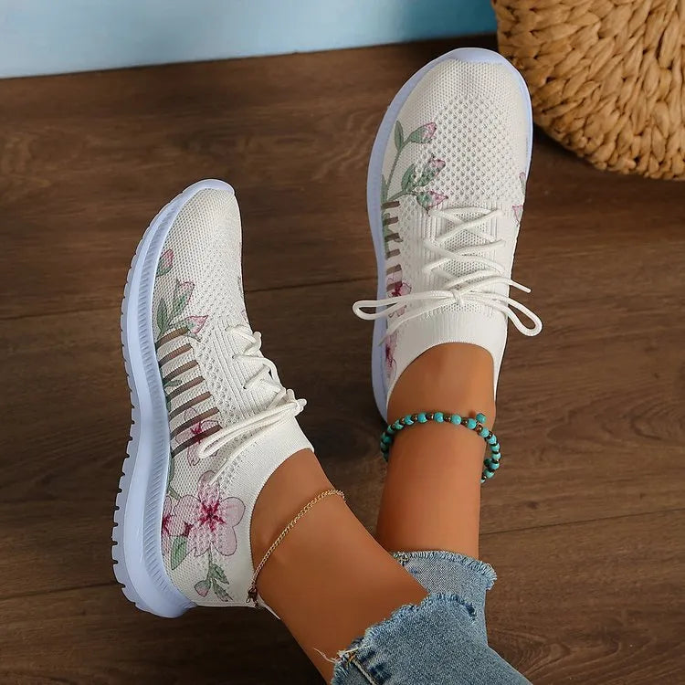 Women's milky white mesh flyknit running shoes with flat heel and rubber sole on grey background
