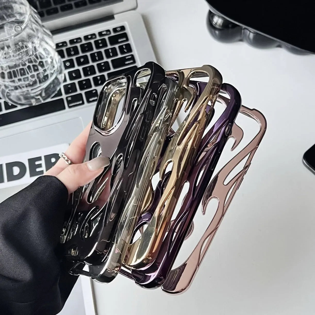 Silver electroplated iPhone case with hollow flame pattern design on a table