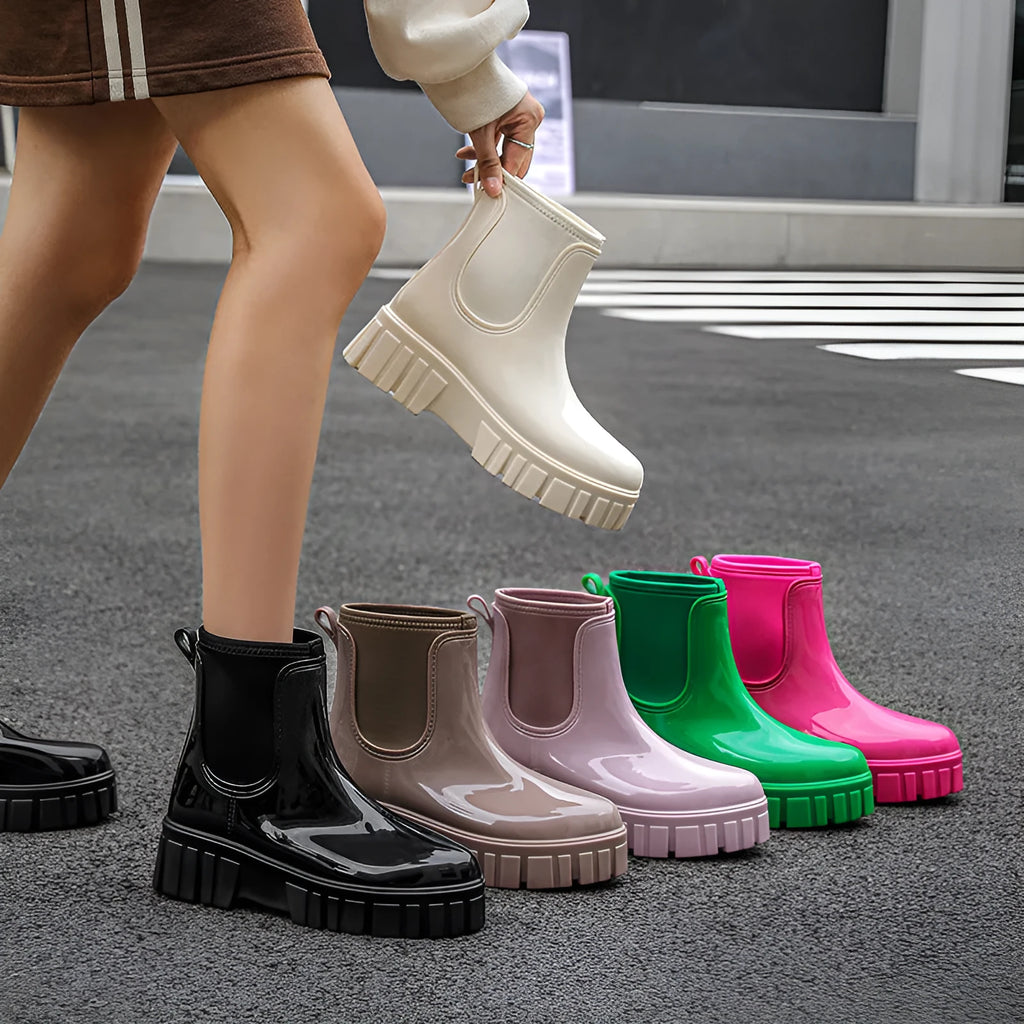 Women's creamy white PVC low tube rain boots with a flat heel on a white background.