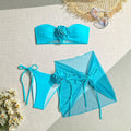 Women's pink tube top swimsuit with large 3D flower and matching skirt set on beach