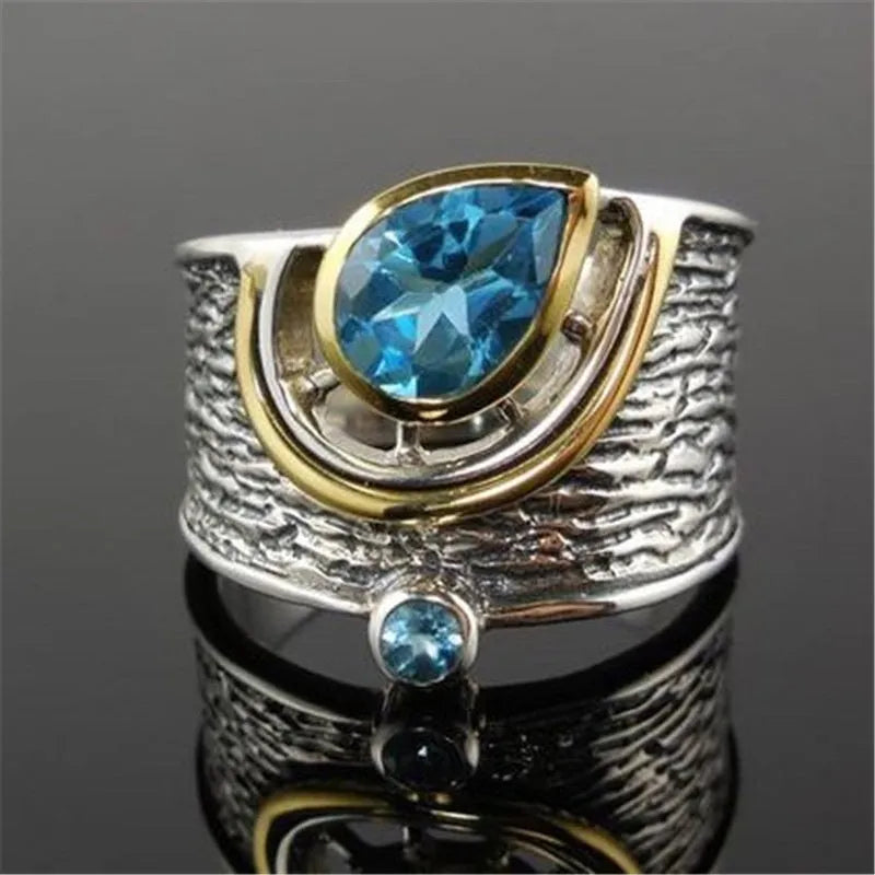 Blue drop-shaped zircon ring with Chinese-style design on a model finger.