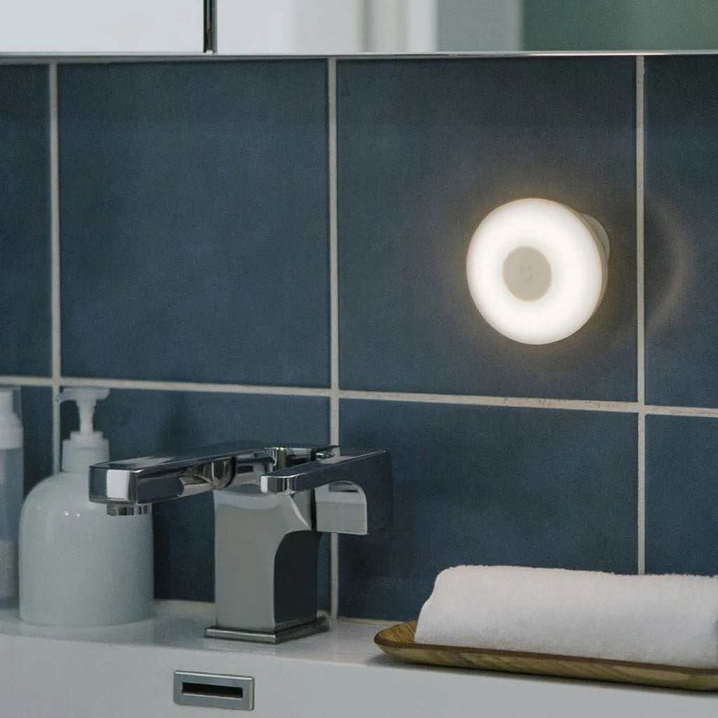 White Mijia Bluetooth bedside table lamp with human body induction on a wooden surface