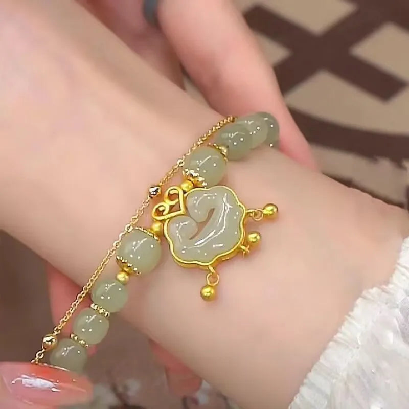 Green women's bracelet with safety lock and bell pendant in drop shape design