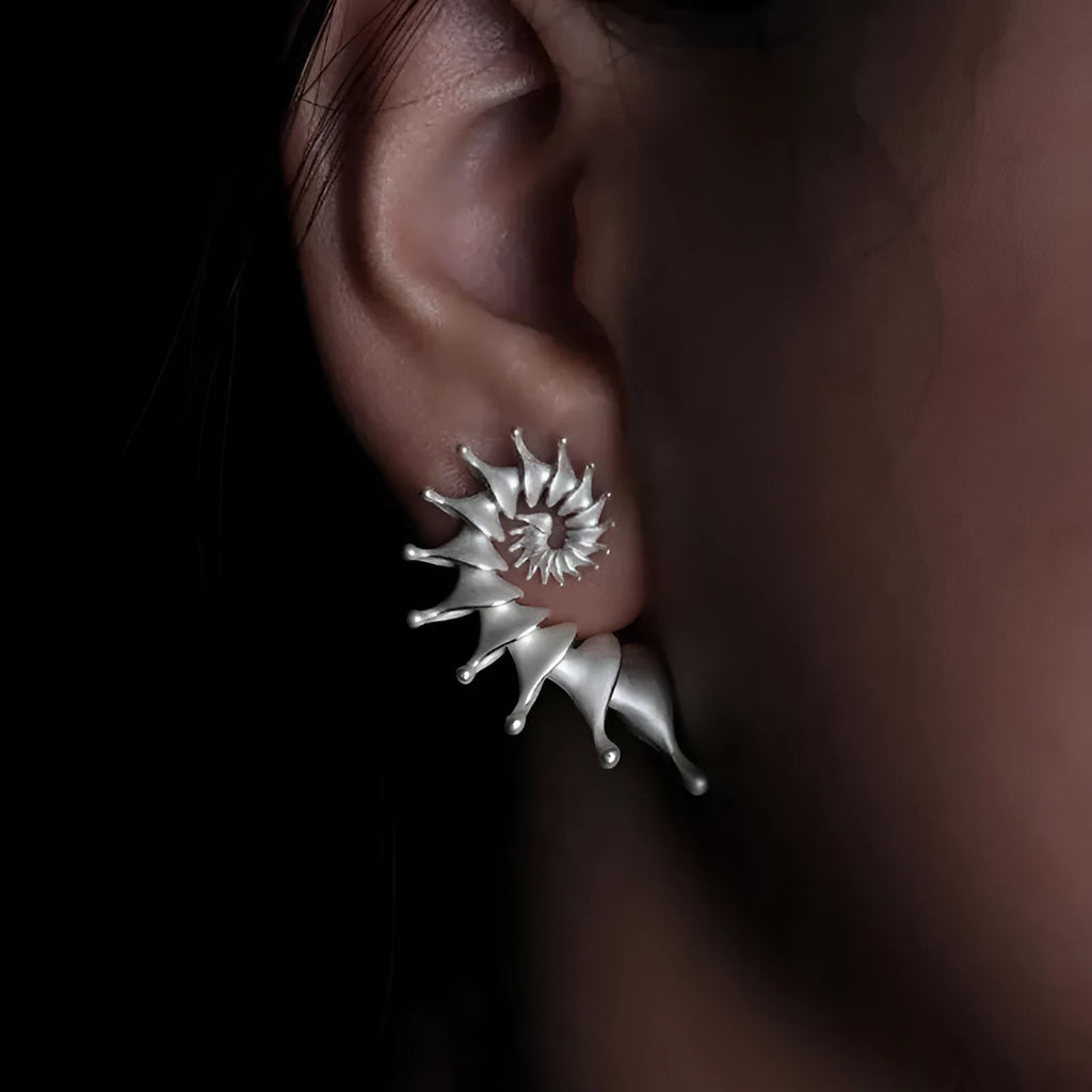 Exaggerated three-dimensional matte conch ear studs in alloy with an irregular simple style.