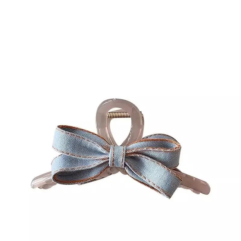 Denim blue bow hair barrette for women with metal clip, shown as a cloth bow hair accessory