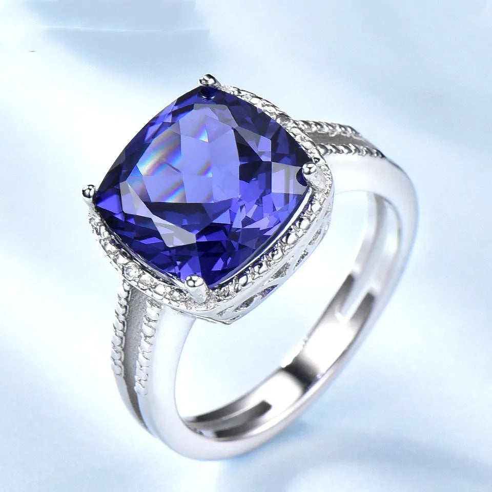 A women's sterling silver ring with a blue Tanzanite gemstone on a silver band.