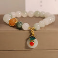 Women's ice jade bracelet with Xiangyun peace buckle and pearl details on a wrist.