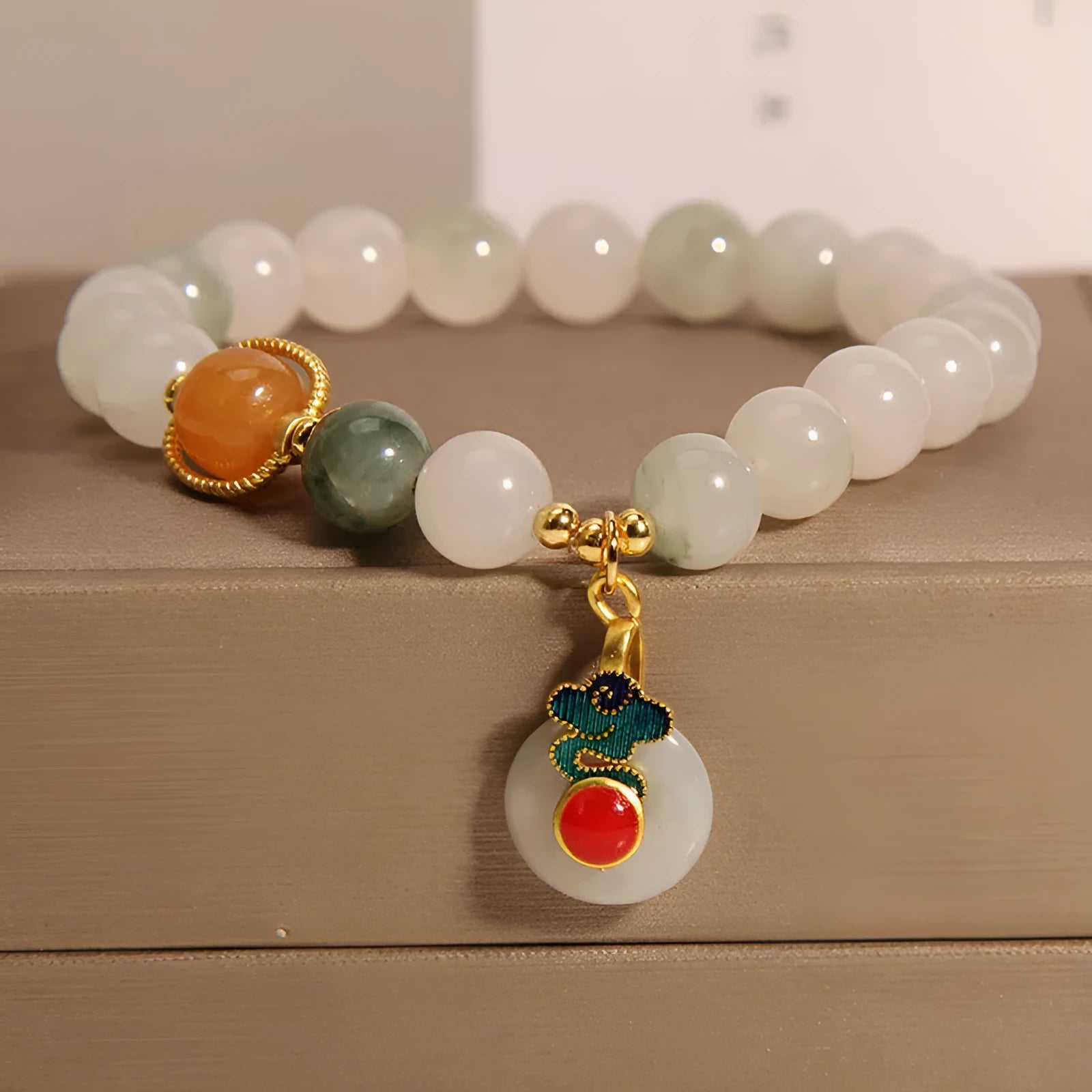 Women's ice jade bracelet with Xiangyun peace buckle and pearl details on a wrist.