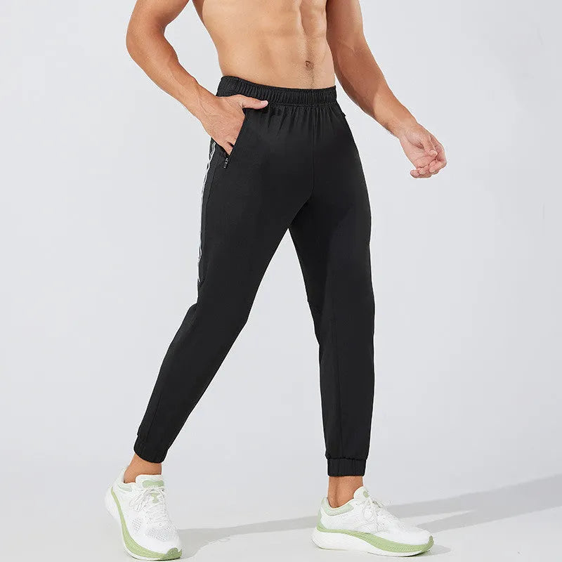 Men's black and navy blue polyester running trousers laid flat, showing full-length design.