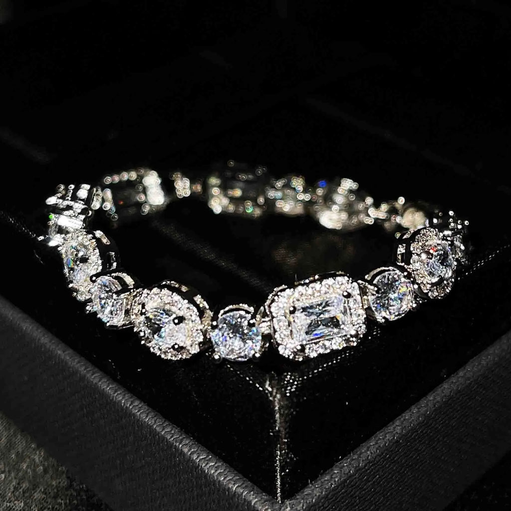 Close-up of women's geometric silver bracelet with sparkling cubic zirconia stones on a wrist, showing adjustable clasp.