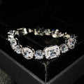 Close-up of women's geometric silver bracelet with sparkling cubic zirconia stones on a wrist, showing adjustable clasp.