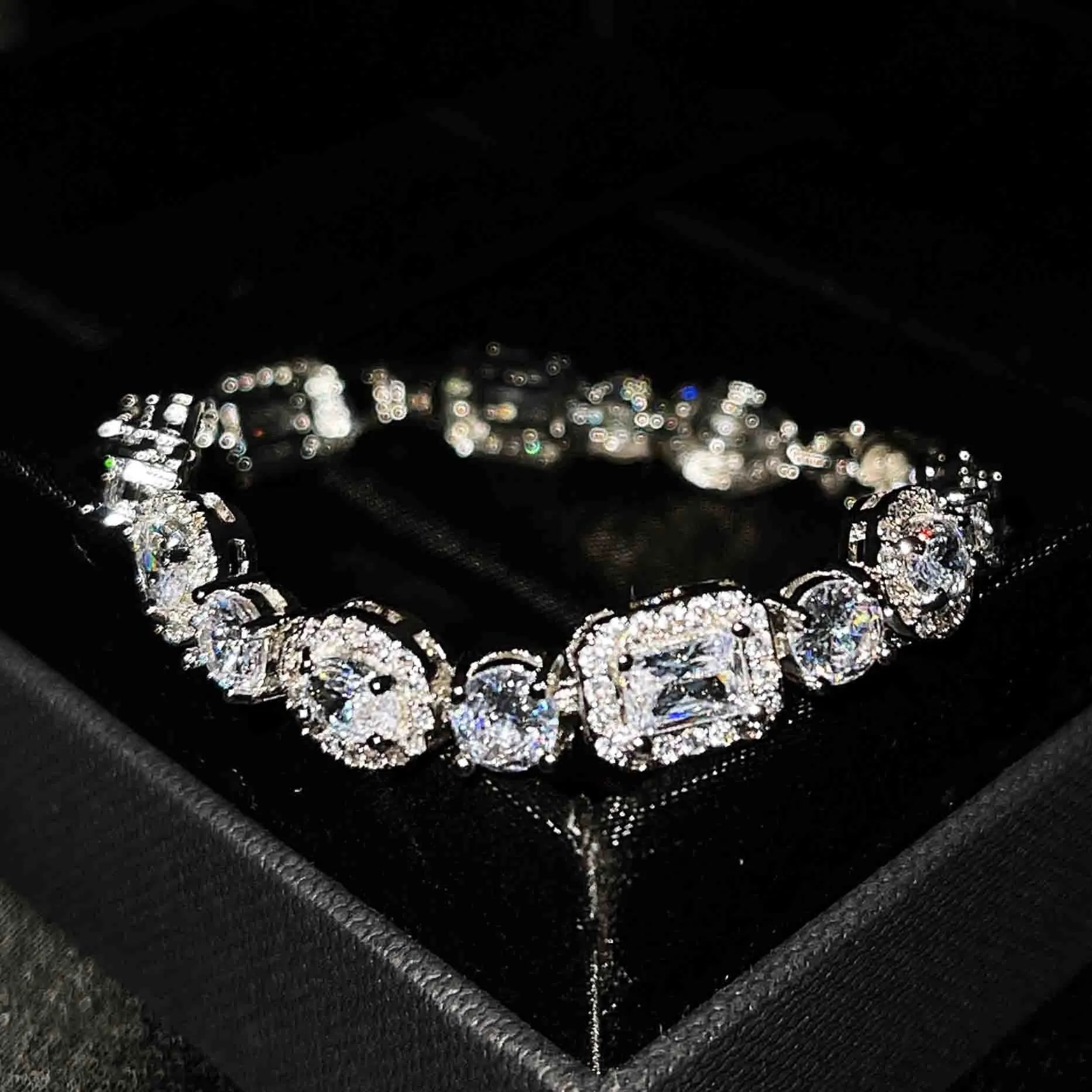 Close-up of women's geometric silver bracelet with sparkling cubic zirconia stones on a wrist, showing adjustable clasp.