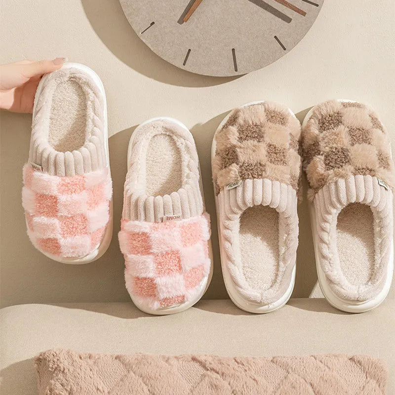 Plaid pattern women's plush indoor slippers in grey with a round toe and flat heel on a non-slip sole.