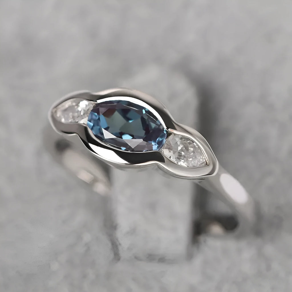 A geometric ellipse-shaped ring with an inlaid zircon, in a white gold colour finish.