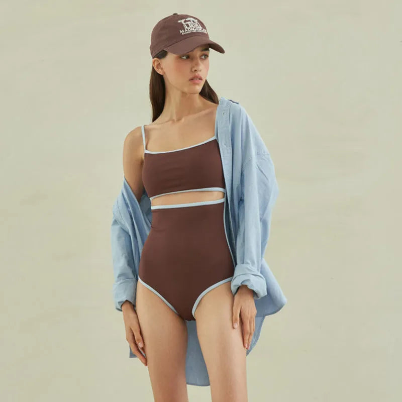 Brown women's one-piece triangle swimsuit on a hanger, showing nylon fabric texture.
