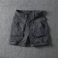 Men's beige cotton cargo shorts with multiple pockets on a straight-leg fit, shown on a neutral background.
