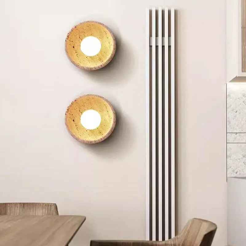 Yellow cave stone wall lamp with textured finish installed above bedside table